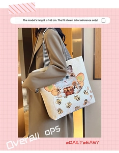 Detailed view of canvas tote bag with cat and bee print on a model with 165cm height
