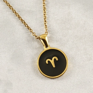 Macro detail of 18K gold Aries constellation pendant with black enamel inlay