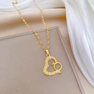 Elegant gold heart pendant necklace with shimmering crystals on a white silk background