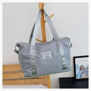 Close-up of a grey waterproof nylon travel bag with expanding bottom zipper and handles