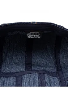 Detail shot of blue denim hat interior showing neat stitching and 100% cotton care label