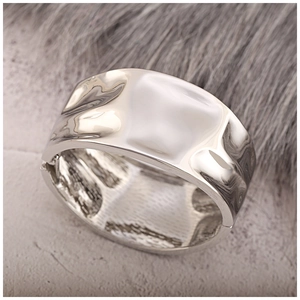 Macro close-up of liquid metal textured silver wide cuff bracelet with wavy surface