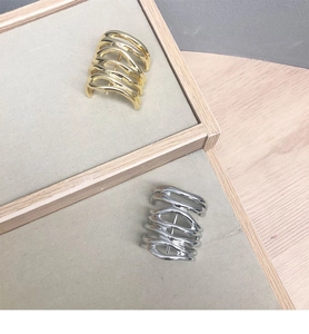 Close-up of gold and silver metallic U-shaped hair clips with wave texture on velvet