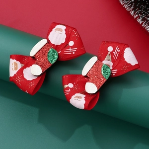 Detail of Christmas bow hair clips with Santa print and glittery stocking ornament