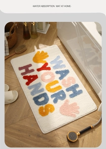 Plush bathroom mat with Wash Your Hands text and colorful palm pattern on white rug