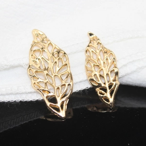 Macro shot of two golden hollow leaf charms for DIY bridal hair accessories