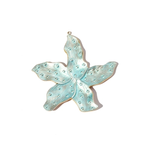 Detailed view of gold starfish pendant with blue enamel and textured surface details