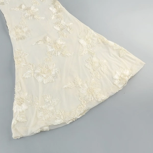 Close-up of 3D floral embroidery on ivory mesh fabric for elegant evening dresses