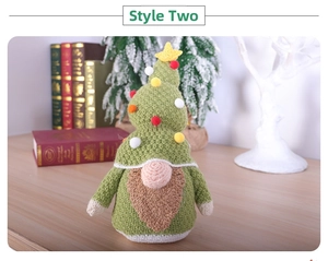 Detail of hand-knitted Christmas gnome with a green tree hat and star topper ornament