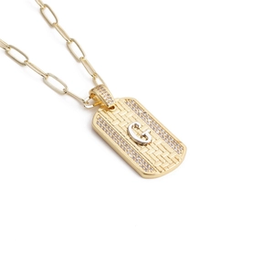 Détail du collier à maillons trombone doré avec pendentif lettre G orné de strass