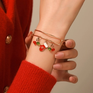 Detailed close-up of adjustable gold Christmas bracelet with festive enamel charms