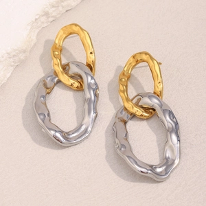 Detail of two-tone hammered texture earrings in gold and silver irregular oval rings