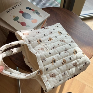 Detail of quilted cotton tote bag with cute bear pattern and simple wish label