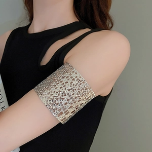 Macro shot of silver wide hollow woven arm cuff with intricate mesh texture on upper arm