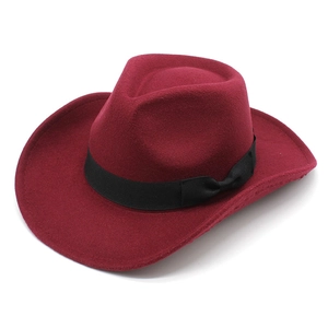 Detail of dark red wool felt cowboy hat featuring a black ribbon band and elegant bow accent