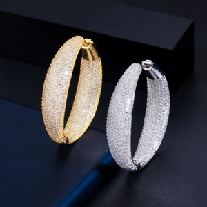 Macro detail of thick gold and silver hoops with micro-paved sparkling cubic zirconia
