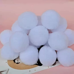 Detailed close-up of fluffy white plush pom poms for DIY crafts and clothing accessories