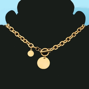 Detail of gold chunky chain necklace with toggle clasp and double round pendants on bust