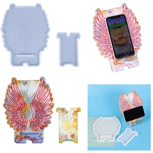 Detail showing silicone molds and finished angel wing phone stand with gold blue glitter