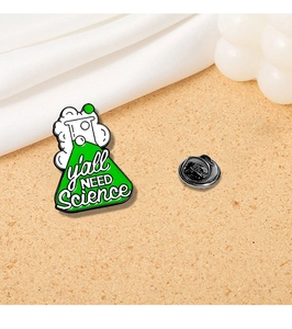 Detail view of science enamel pin with green flask and y'all NEED Science text slogan