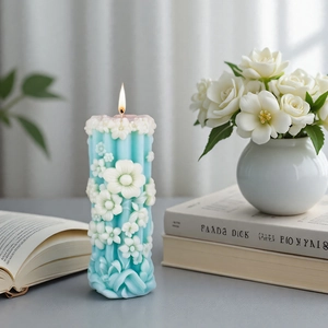 Floral cylinder candle with white relief carvings shown in an elegant home decor setting
