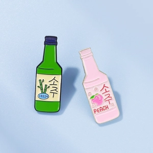 Detail view of colorful soju bottle enamel pins featuring peach and bamboo designs