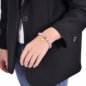 Pink zebra stone bead bracelet with yellow sunflower pendant on a woman's wrist