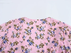 Dettaglio top bohémien in chiffon rosa con stampa floreale blu e scollatura rotonda
