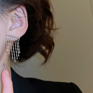 Silver tassel earrings with hanging metal chains shown on a model in a black blazer