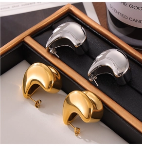 Detailed view of layered teardrop earrings in gold and silver finish inside a jewelry box