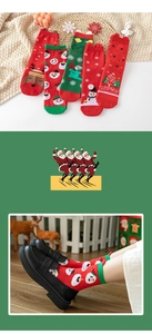 Detail of red Christmas socks featuring knit Santa, elk patterns and holiday textures