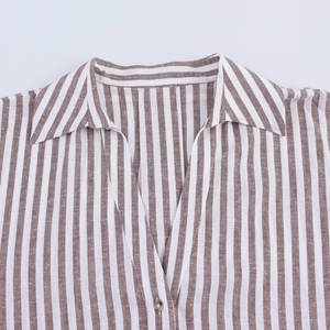 Detail of striped brown and white lapel shirt with V-neckline and high-quality linen texture