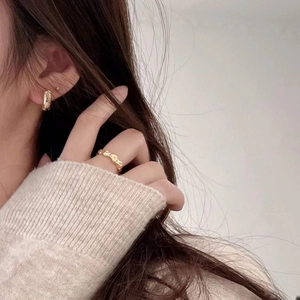 Minimalist gold chain ring and circular hoop earrings set on a model in knitwear
