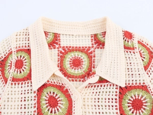 Detail of crochet knit collar with retro floral patterns and button on short sleeve cardigan