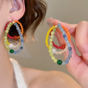 Detail of colorful beaded hoop earrings on model and handheld showing vibrant natural stones