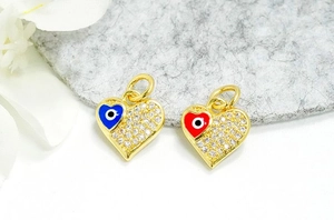 Detailed macro of 18K gold plated heart evil eye charms with cubic zirconia stones