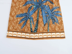 Detail of tropical palm tree print on textile dress hem with decorative border