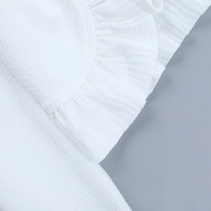 Détail du tissu seersucker blanc avec bords à volants et texture plissée élégante