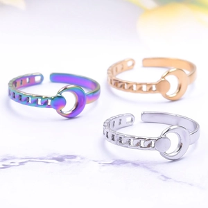 Three celestial moon chain open rings in rainbow, gold, and silver finishes on marble