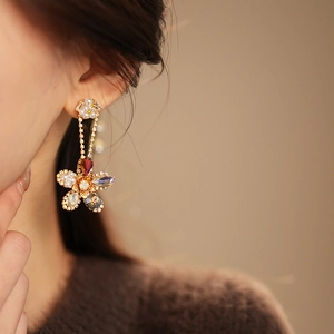 Macro detail of floral drop earrings with multicolored crystals and white pearls
