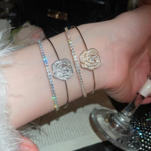 Detailed macro view of zircon flower bracelets and sparkling layered tennis chains