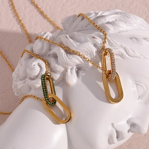 Artistic detail of gold double-ring heart pendants with green and white crystals