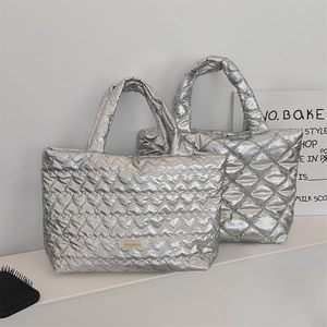 Close-up of silver quilted puffy tote bags showing metallic finish and diamond stitching