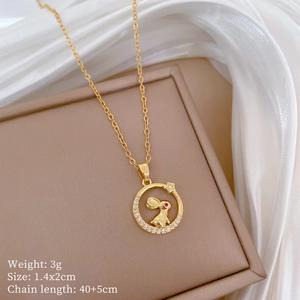 Detail view of a gold rabbit ring necklace with crystals on beige jewelry box