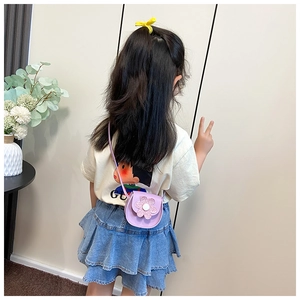 Detail of a purple glitter flower shoulder bag worn by a little girl in a sweet setting
