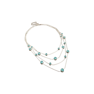 Minimalist silver multi-layered necklace with blue zircon stones on a white background