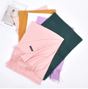 Close-up of colorful cashmere scarves with tassels and premium material labels