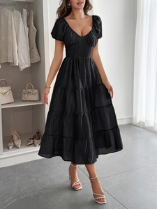 Dettaglio di un abito lungo nero a balze con scollo a V e maniche a sbuffo stile casual