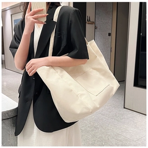 Detail of canvas tote bag with functional outer pocket shown in a modern lifestyle setting