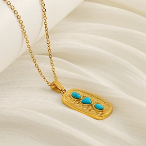 Detail of vintage gold-plated stainless steel necklace with three turquoise stones on a pendant